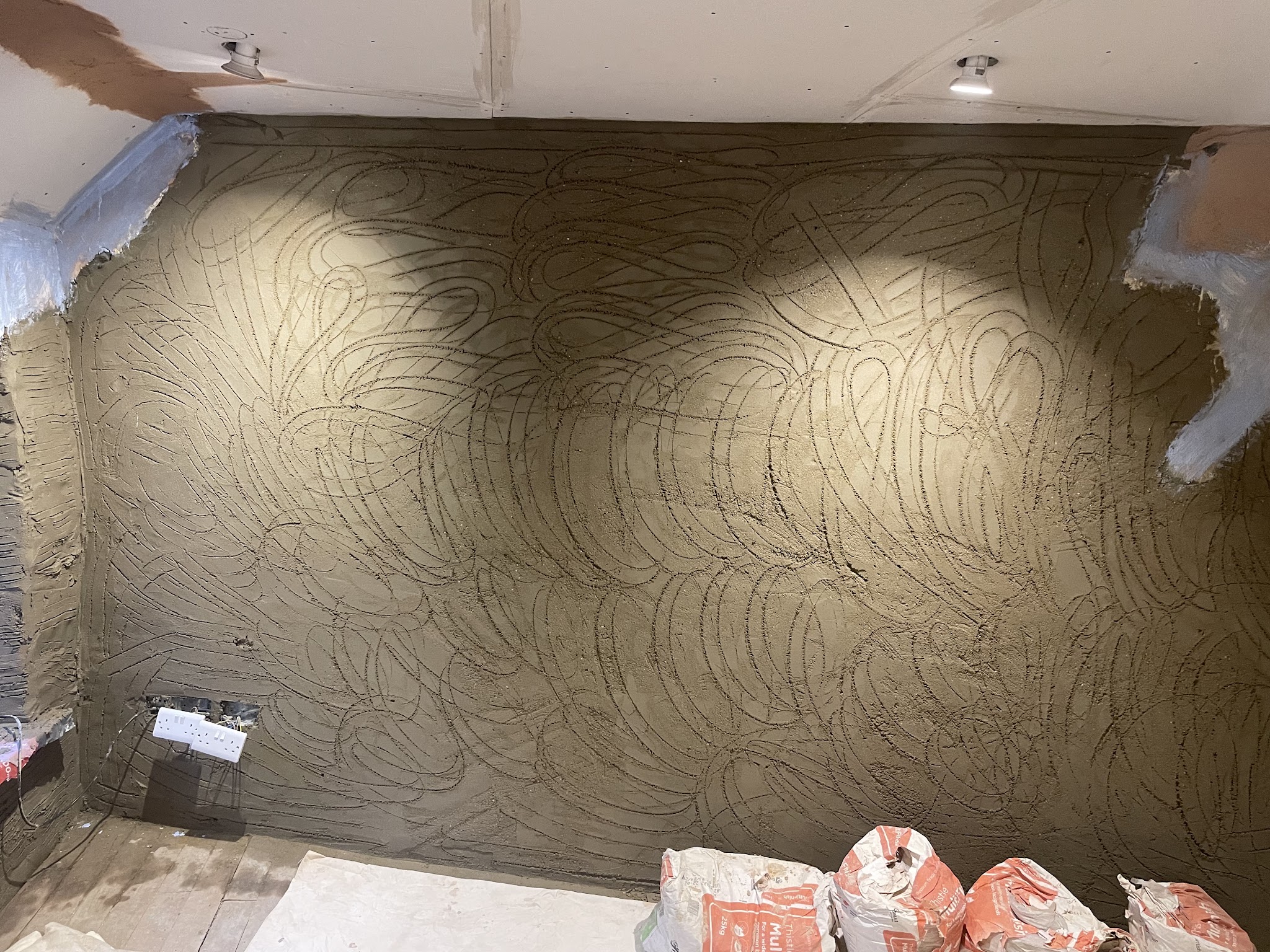 Scratch coat render on an internal wall