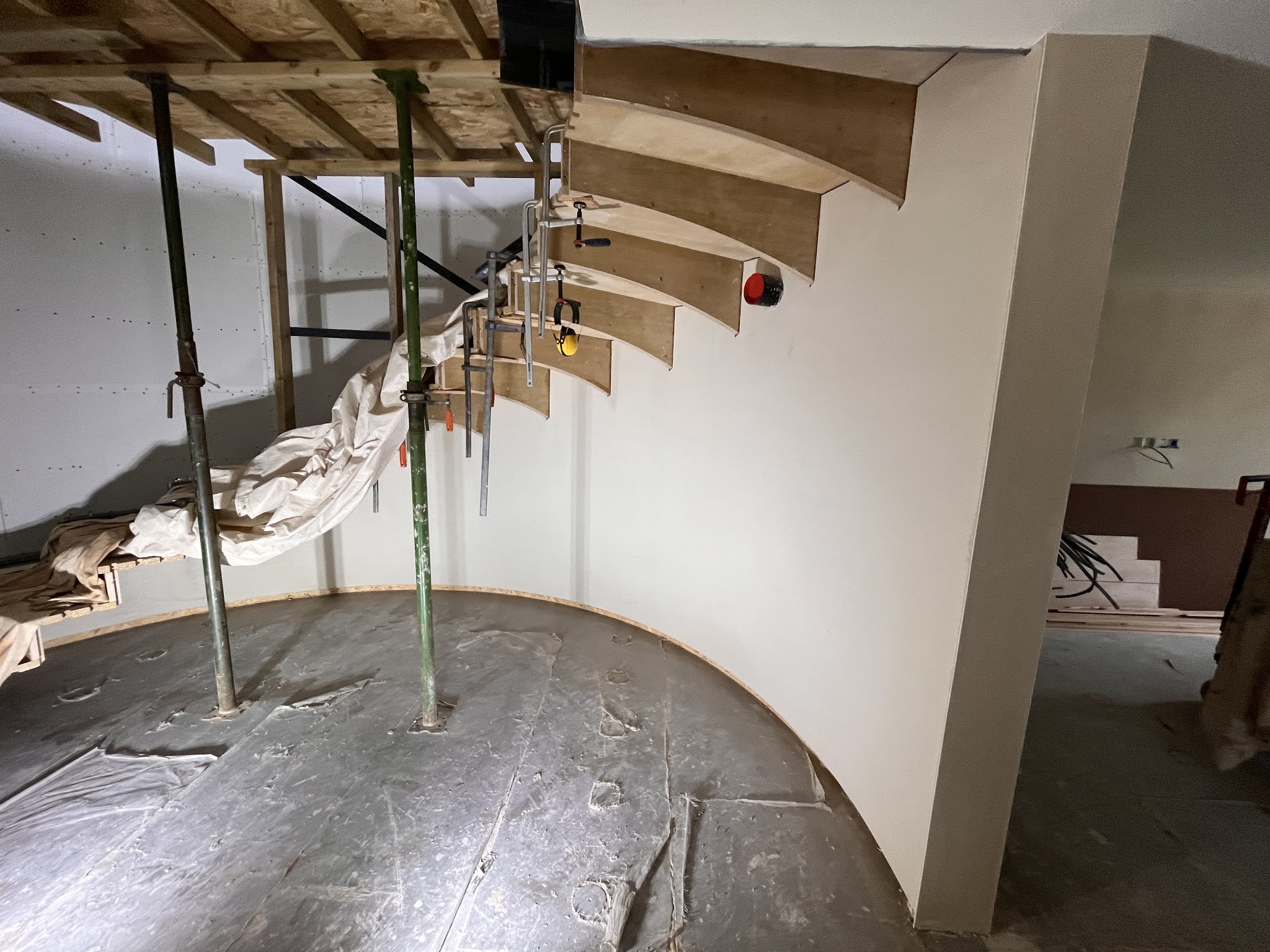 Curved wall under a staircase, freshly plastered
