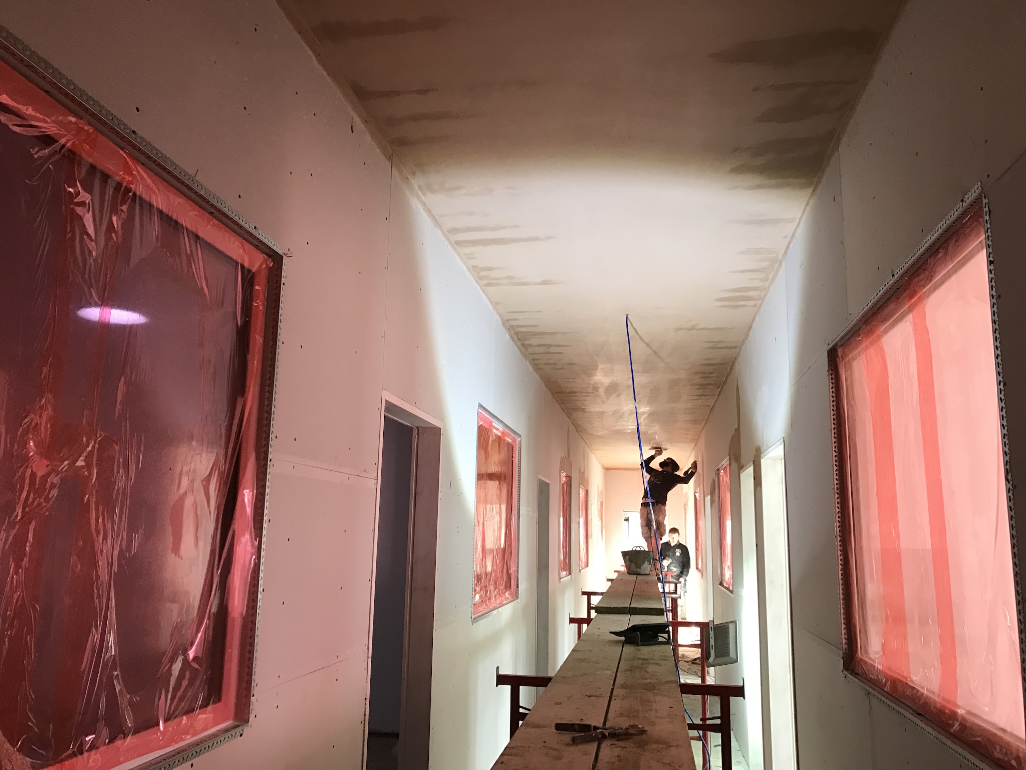 Skimming the ceiling of a long corridor with the windows sheeted