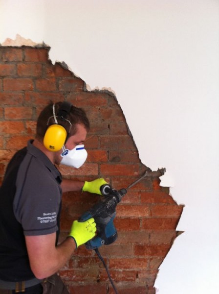 Hacking off old plaster back to the brickwork