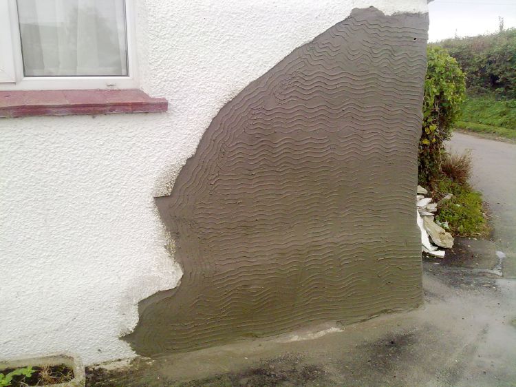 The first scratch coat of render