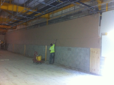 Plastering a tall shop wall from the floor