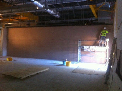 Plastering from a scaffold tower in a shop fit